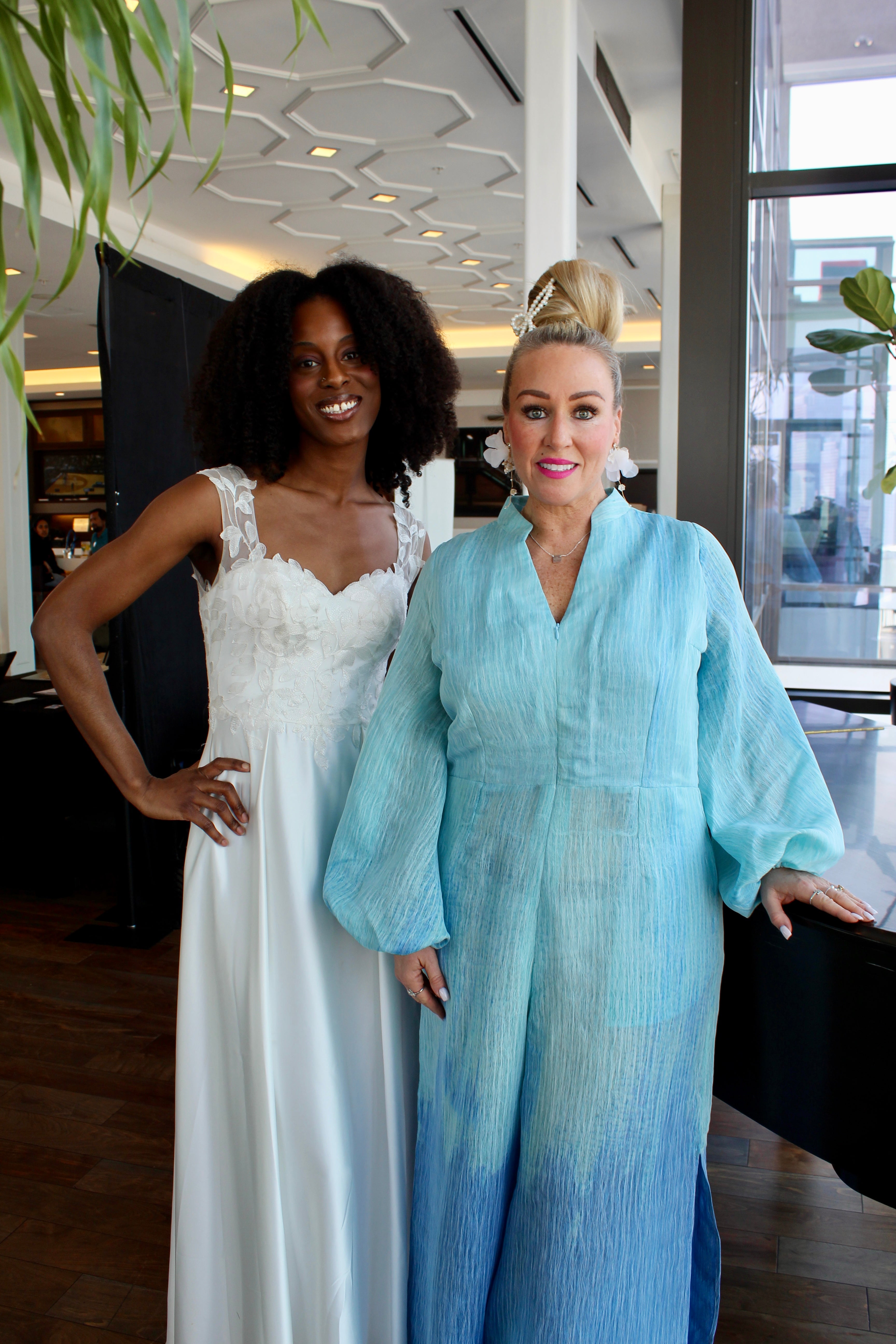 White woman wearing Blue Ombre jumpsuit as a bridesmaid standing next to black woman as a bride