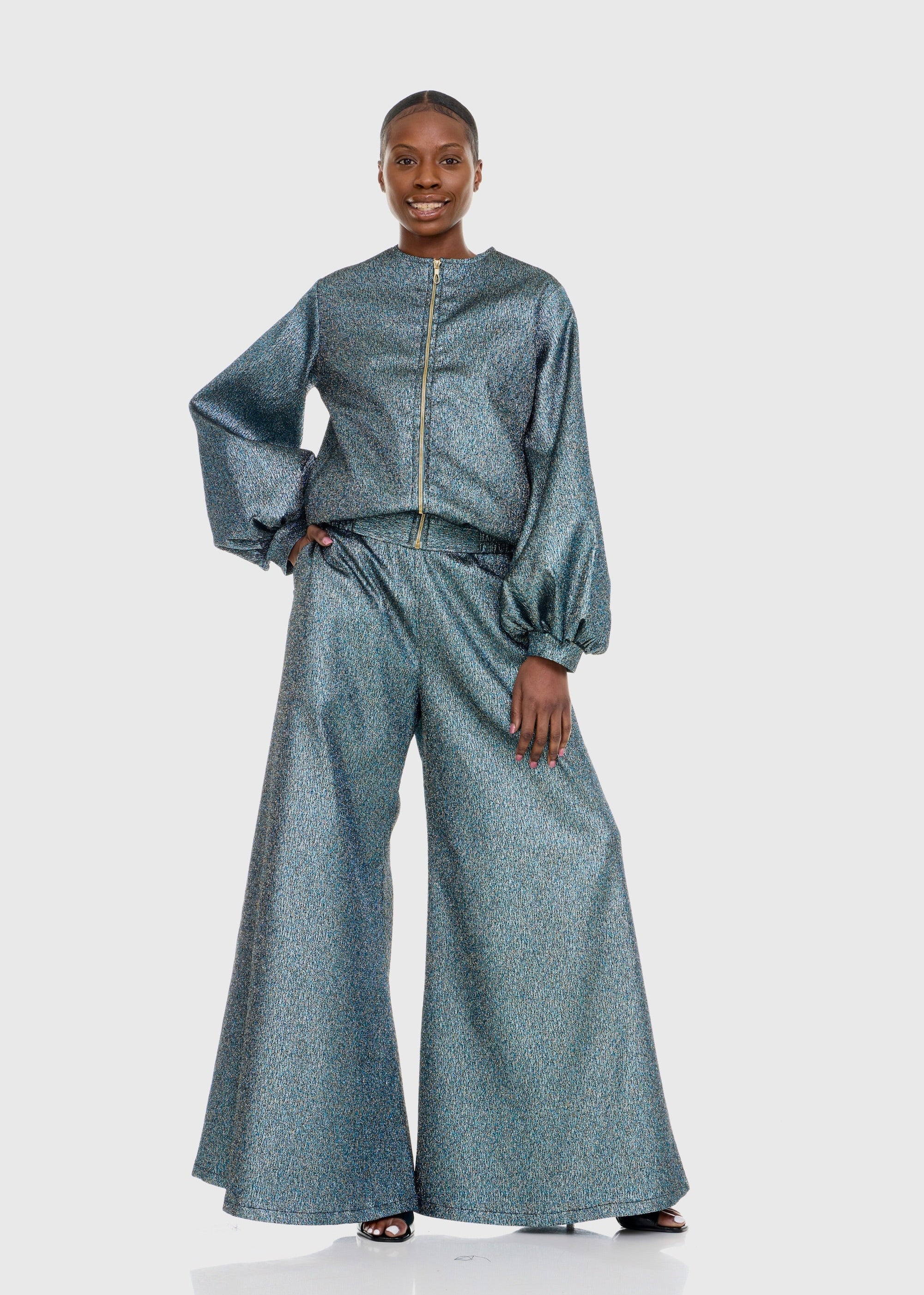 Black woman wearing Green Shimmer Bomber Jacket with matching Flare pants with left hand in pocket