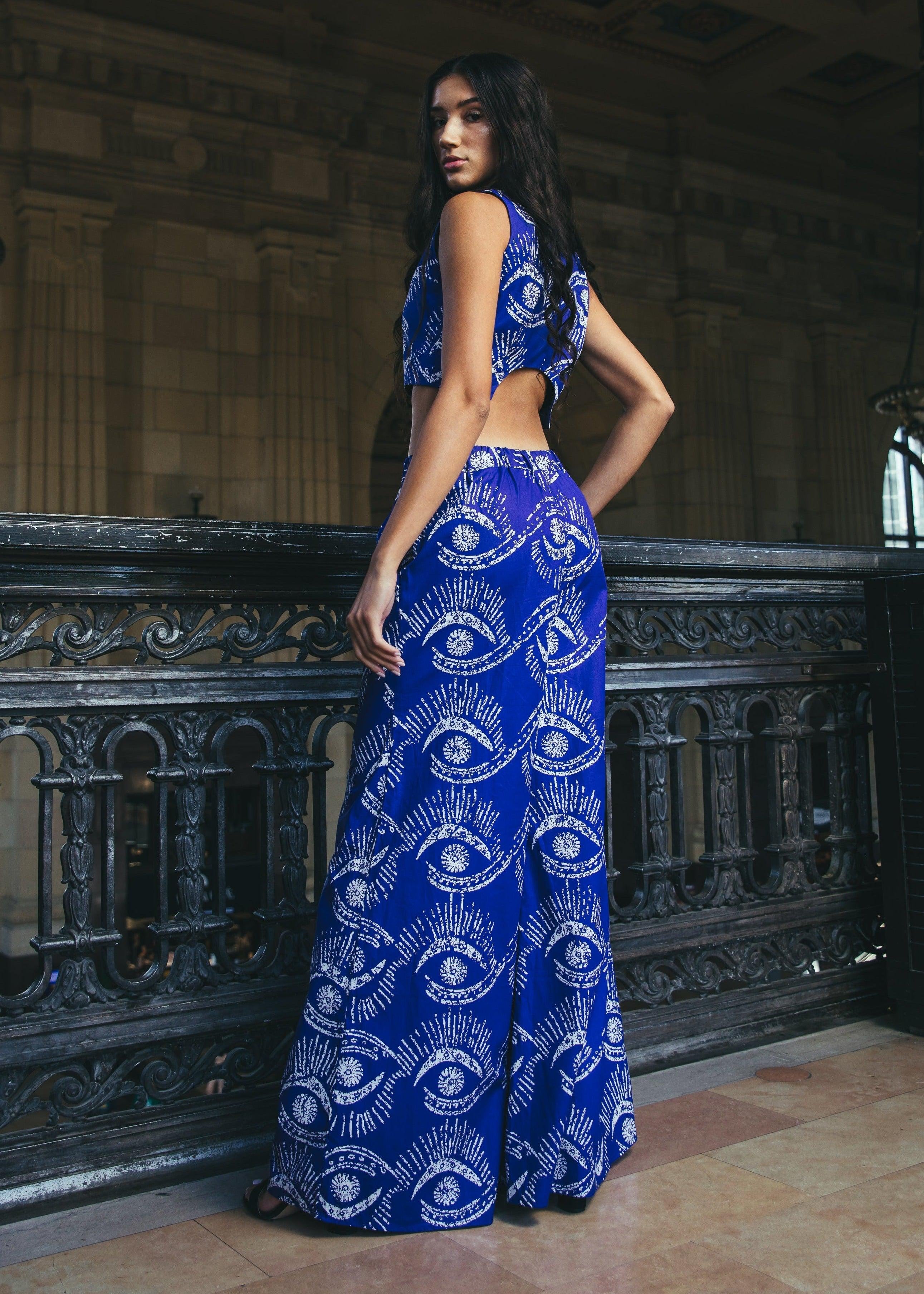 Model wearing Wasini Crop Top in blue and white, posing by a railing