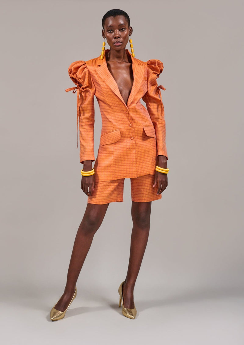 Model standing sideways showing the cut-out details on the shoulder of the Adderley Tuxedo Jacket styled with the Foreshore Bermuda Shorts