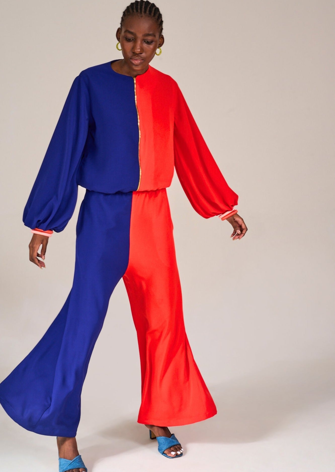 Shot of model standing with legs apart to show the flared details of the Greenpoint Color Block Pants, styled with the Mouille Colour Block Bomber Jacket by KAHINDO