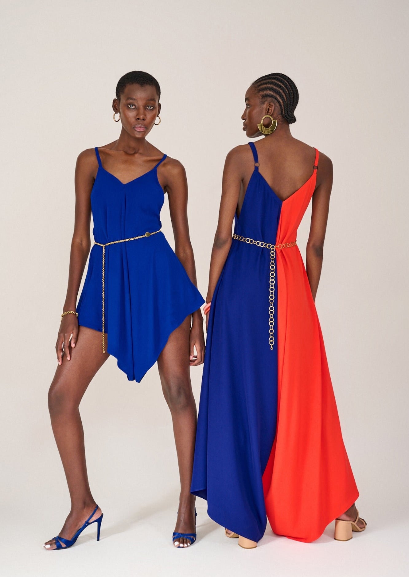 Two models posing together, one facing forwards wearing the Kloofstreet Playsuit and the other facing backwards in the Longstreet Colour Block Jumpsuit by KAHINDO