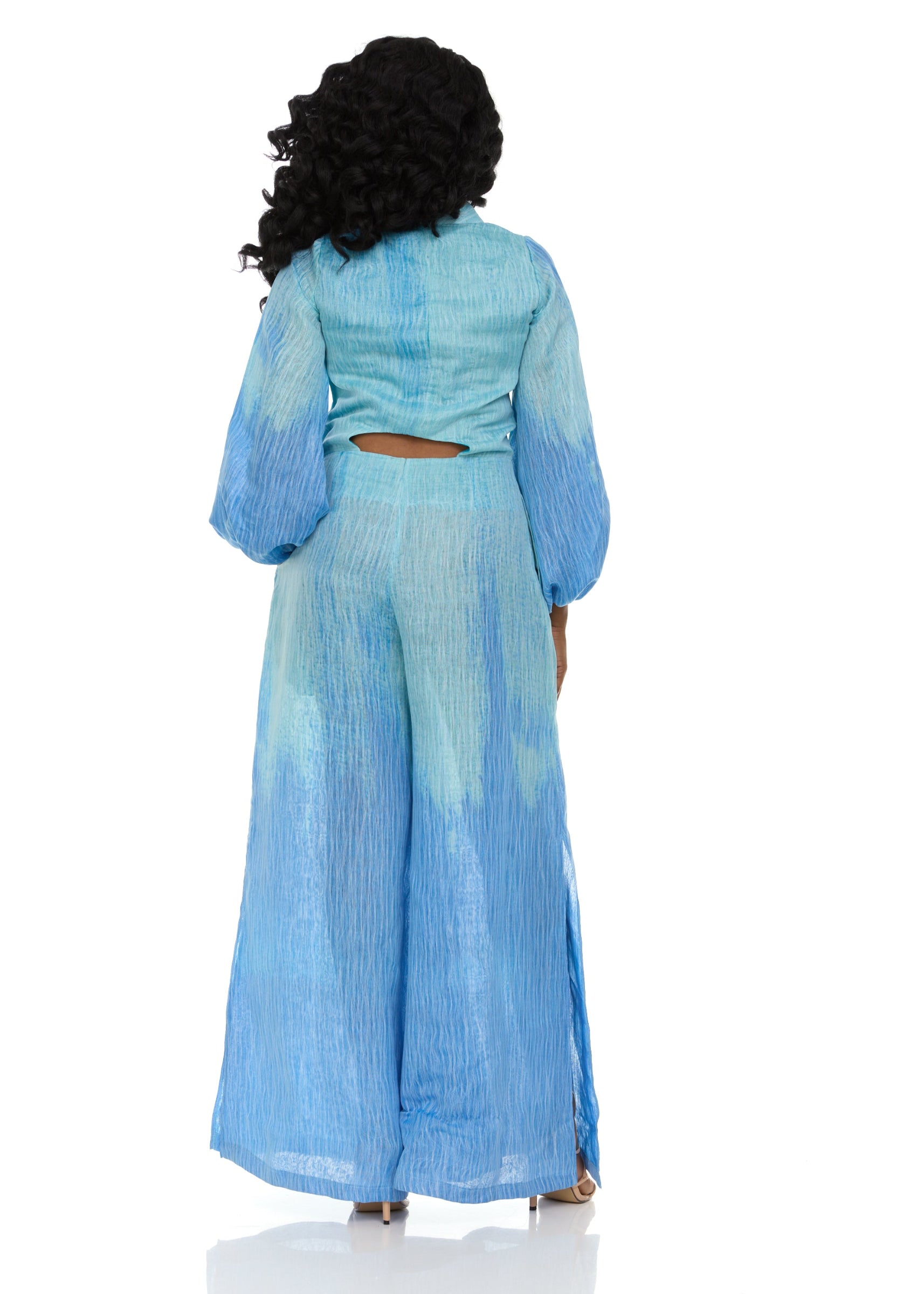 Back view of a woman wearing the Blue Ombre jumpsuit with cut-out back