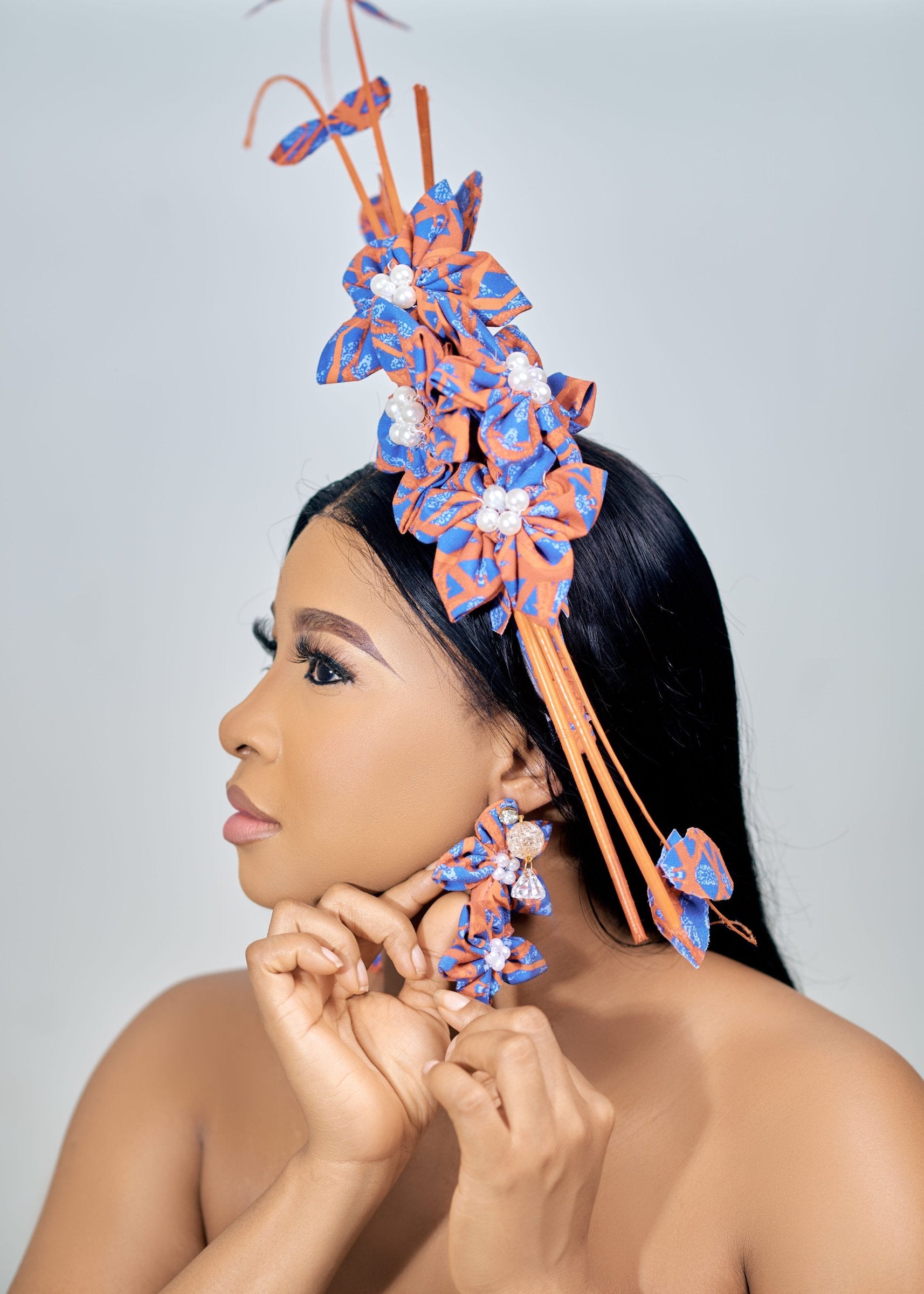 Model wearing blue and orange fascinator and matching earrings