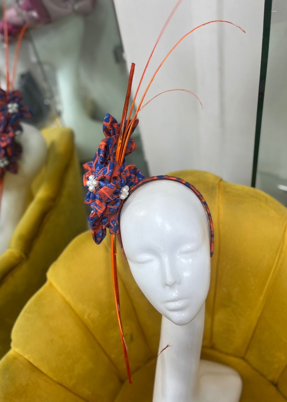 Orange and blue fascinator on mannequin