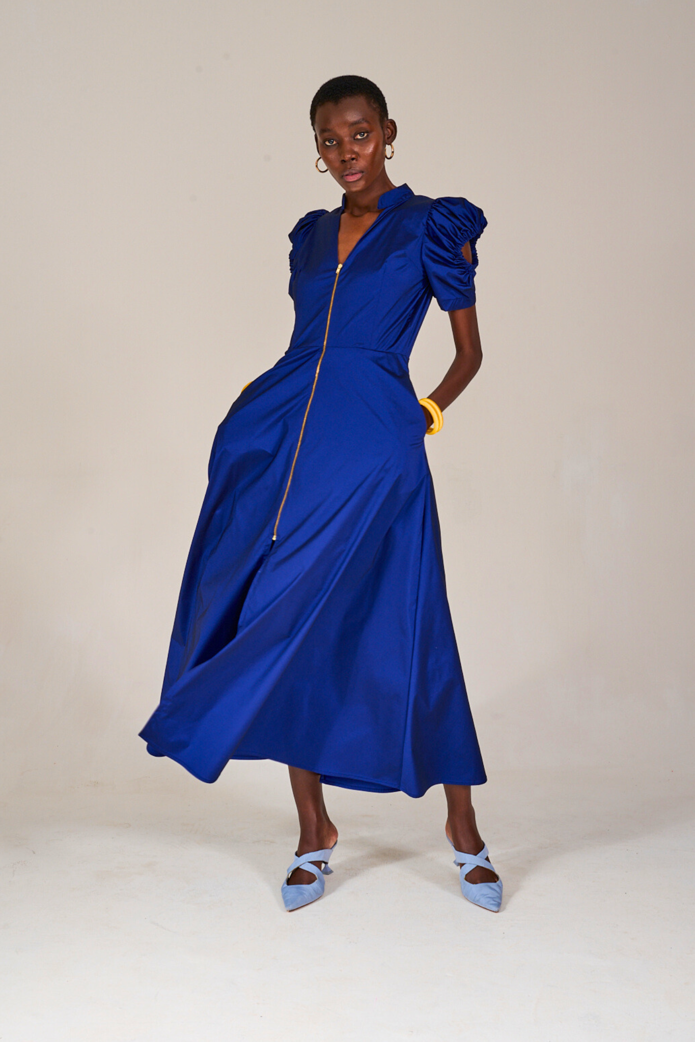 Model posing with hands in pockets of the KAHINDO Nines Blue Dress