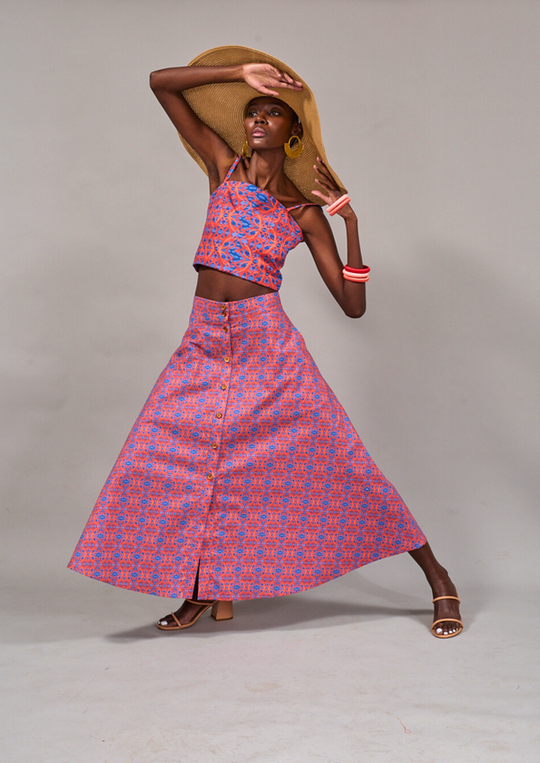 Model posing with hands on her wide brim straw hat leaning onto one side wearing the KAHINDO Campsbay Skirt styled with the Tang Top