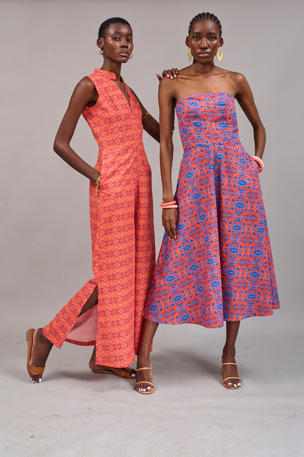 Models posing together wearing the Watershed Sleeveless Jumpsuit and the Waterfront Strapless Dress by KAHINDO