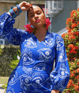 A close-up of a woman wearing the Bahari Print Jumpsuit with a flower accessory in her hair