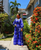 A model standing outdoors in a garden wearing the Bahari Print Jumpsuit