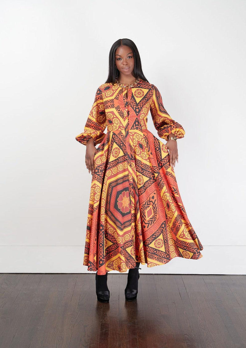 A woman modeling the Bezeleni Maxi Shirt Dress with a vibrant red and orange design