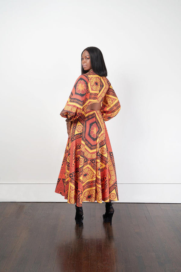 The Bezeleni Maxi Shirt Dress showcased by a model, featuring an orange and yellow patterned long dress