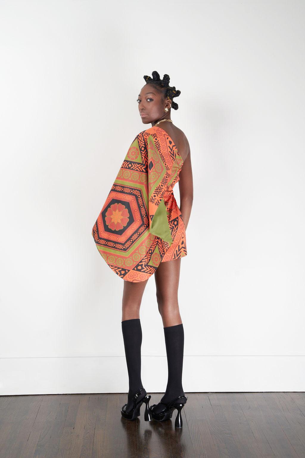 A model showcasing the Kivu Dress with vibrant patterns and high heels