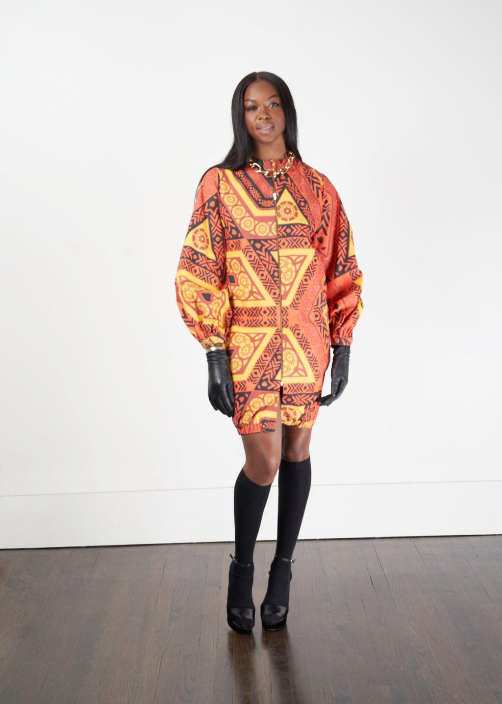 A woman modeling the Kyoga Long Bomber Jacket with a colorful pattern