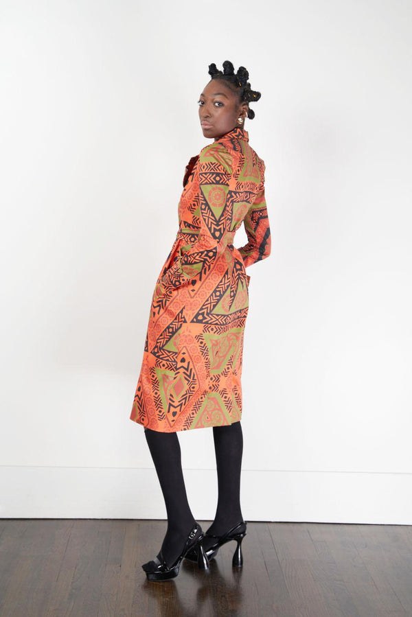 model wearing trench coat in african inspired print orange and green