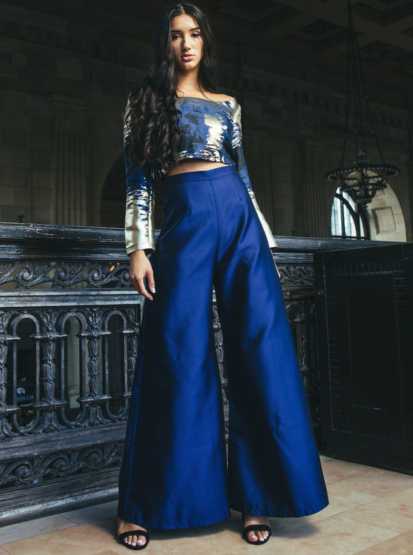 The 'Zendaya Top' paired with blue pants modeled by a woman on a balcony