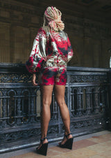 Model showcasing Aberash Shorts paired with a red and gold jacket