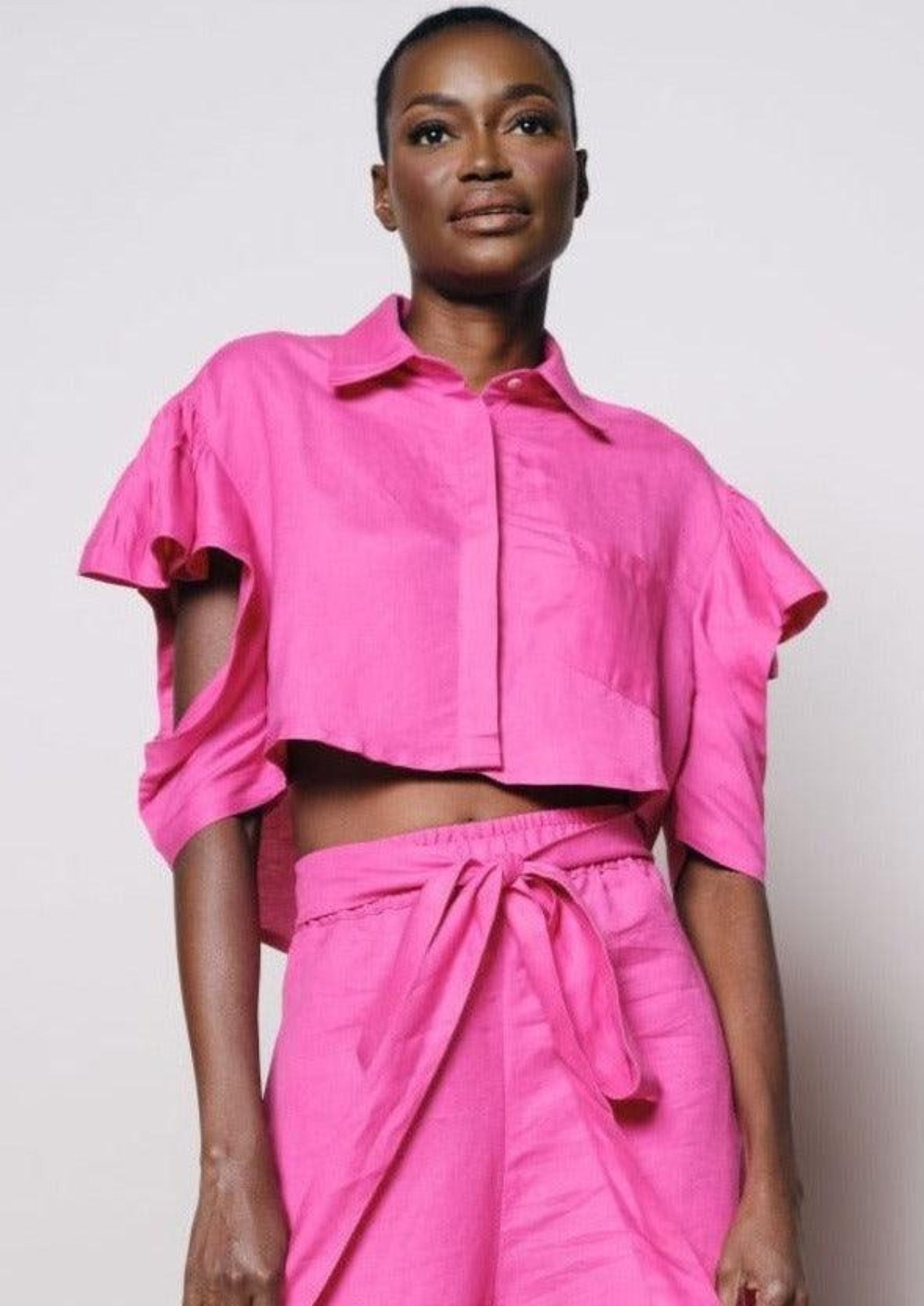 A model wearing the Baobab Crop Top paired with pink shorts