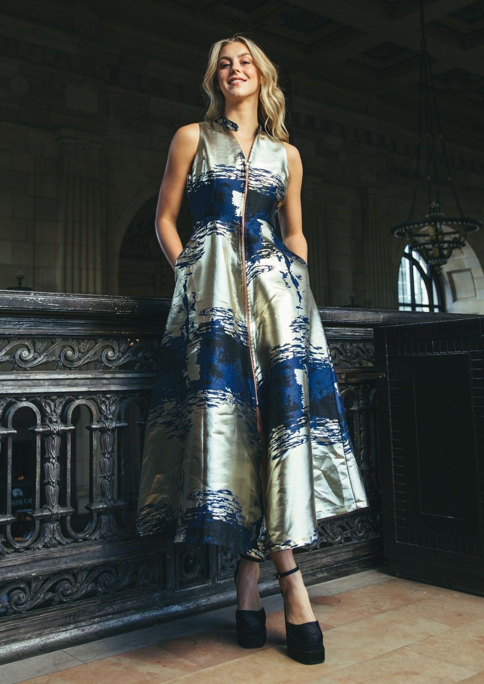 Model posing in the Chidi Midi Dress with blue and gold accents