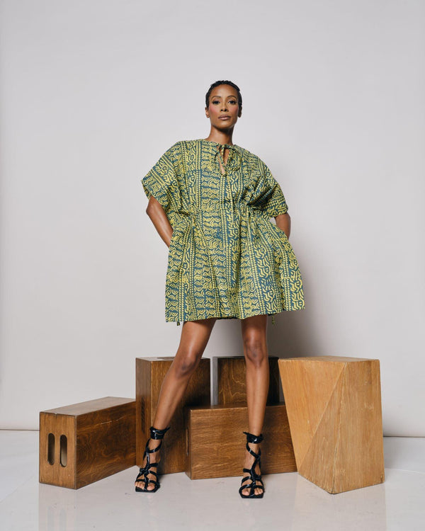 A model showcasing the Ethiopia Kaftan while standing on wooden blocks