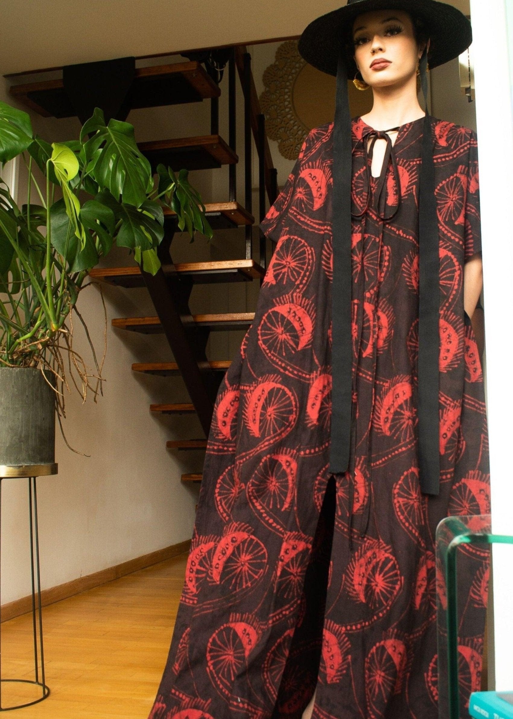 A model showcasing the Luhya Kaftan with a black hat and standing pose