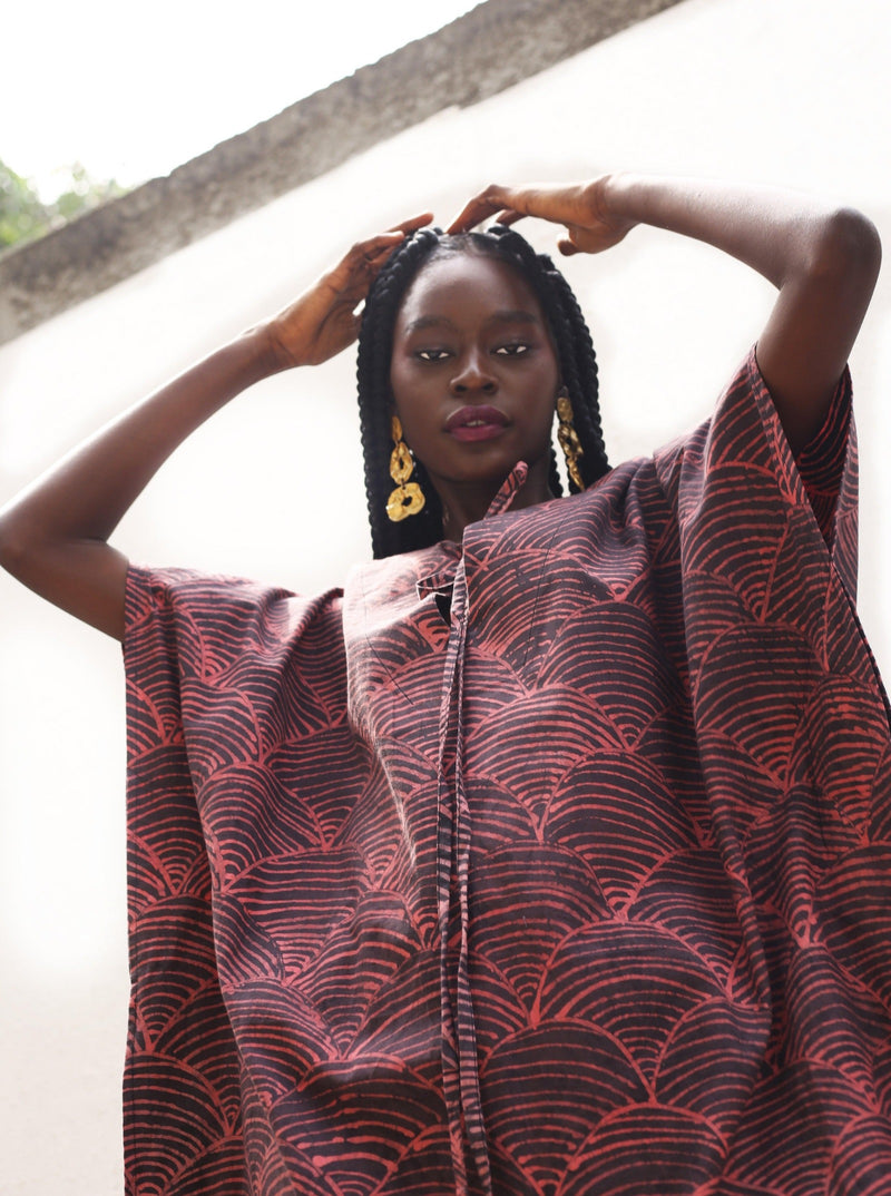 A model adorned in the Luhya Kaftan featuring African print and gold earrings