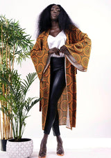 A model showcasing the Oxy Robe in a brown and gold color scheme