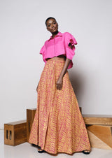 A woman modeling the Praslin Maxi Skirt with a pink top