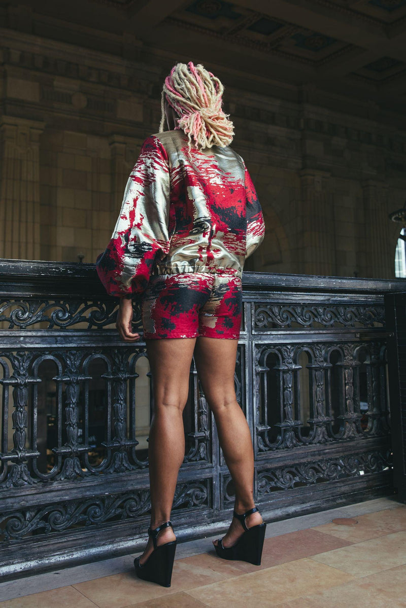model wearing red and gold shorts with matching jacket from the back